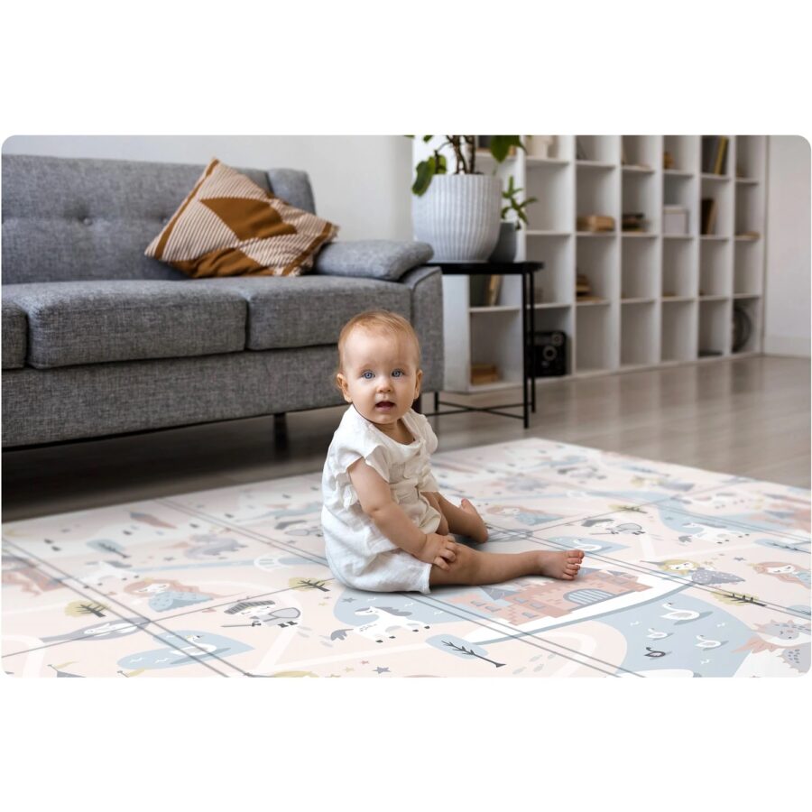 Vaikas žaidžia ant pasakų tematikos lavinimo kilimėlio