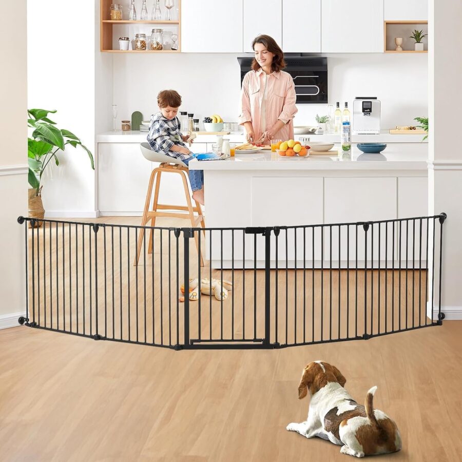 Mama virtuvėje su vaiku, atskirtu apsauginiais varteliais