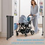 Mama stumia vežimėlį pro atidarytus vartelius